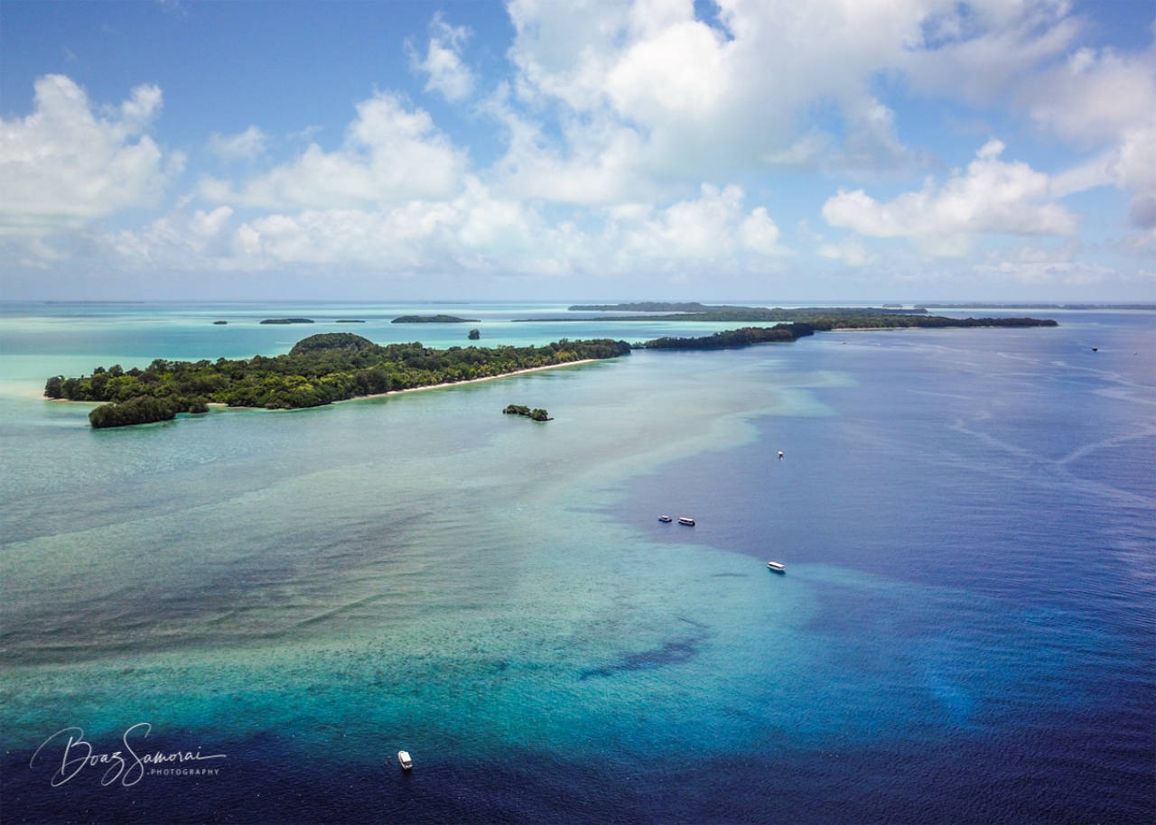 Aerial photo of the Blue Corner Palau, showing the reef structure of Blue Corner and Ngemelis island in the background